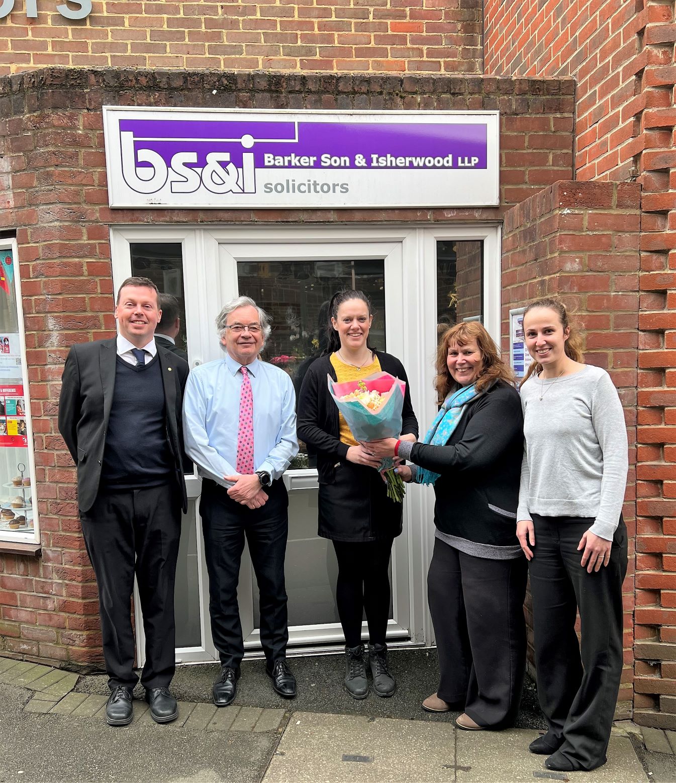 Group of 5 people celebrating the the promotion of Samantha Travella to Partner.