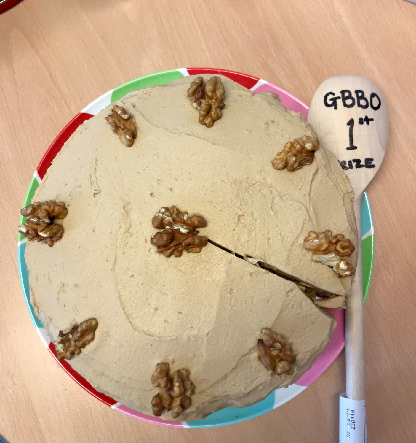 Walnut and coffee cake with first prize awards on wooden spoon.