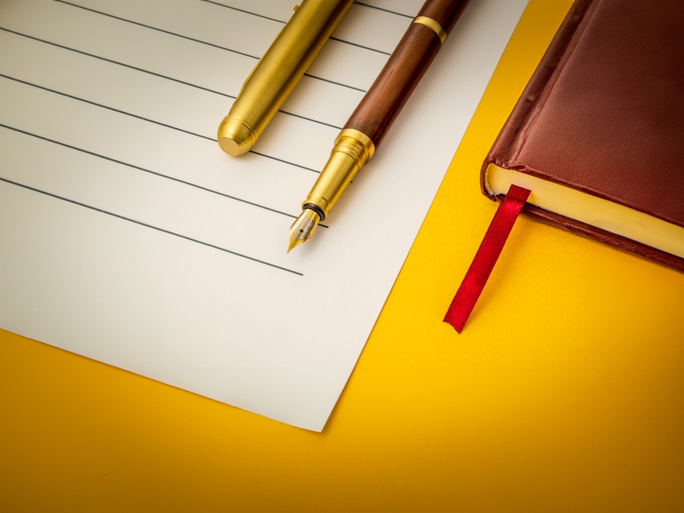 Legal office still life on yellow table with fountain pen on sheet and legal book.