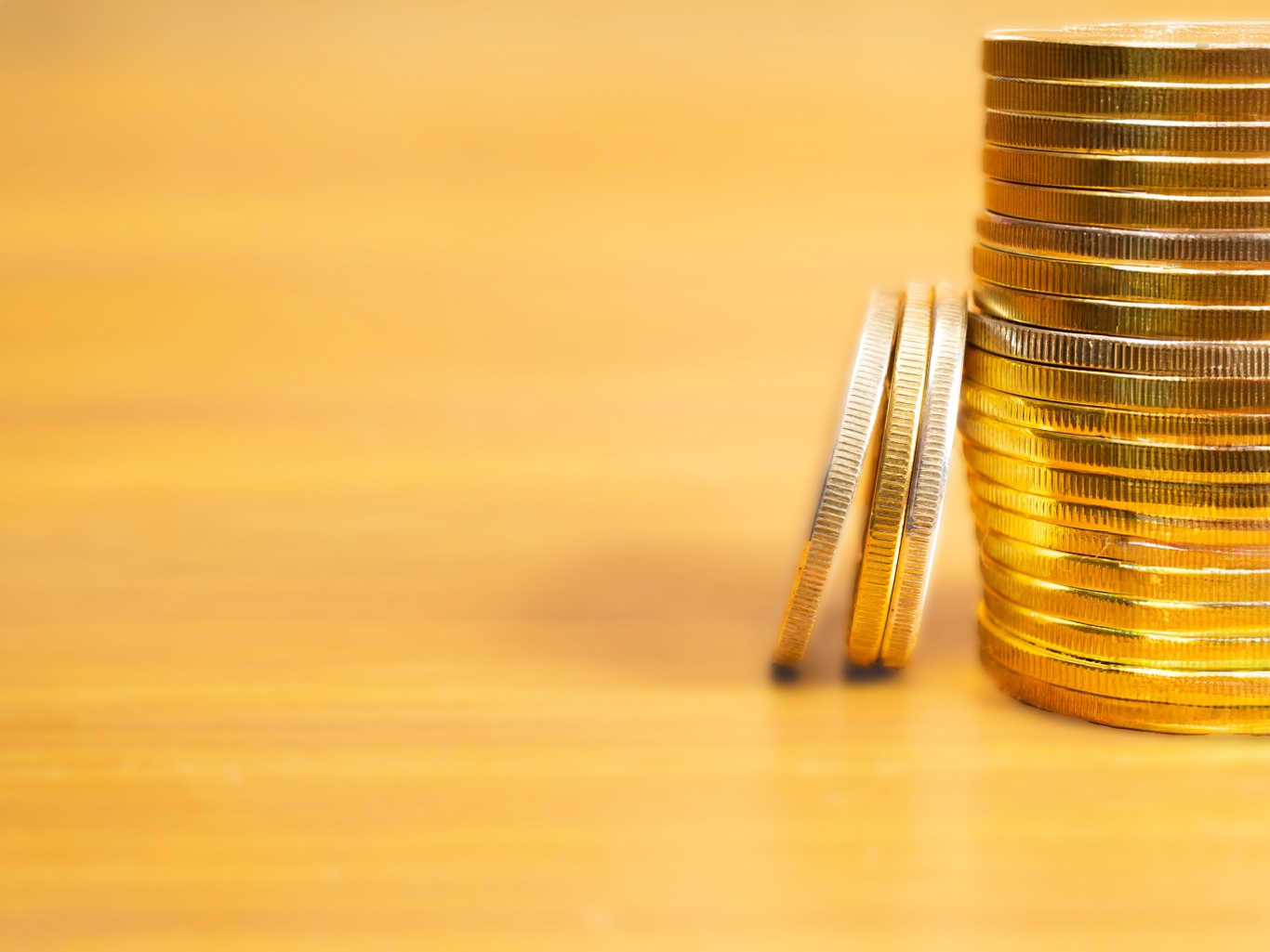 Rows, stacks of coins with blurred background and blank space.