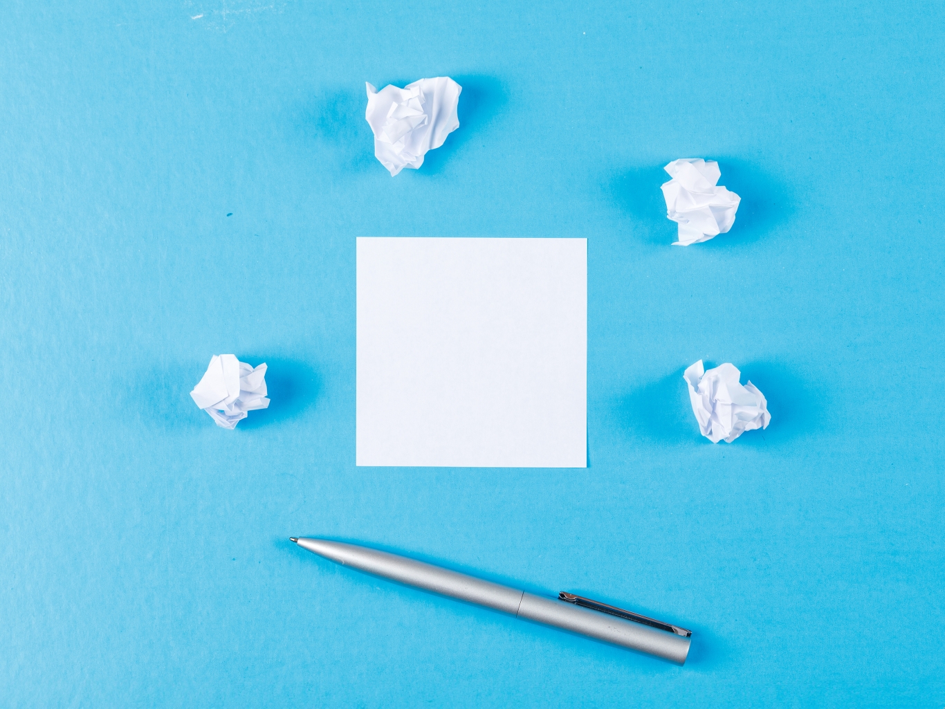 Business concept with crumpled paper wads, sticky note, pen on blue background flat lay.