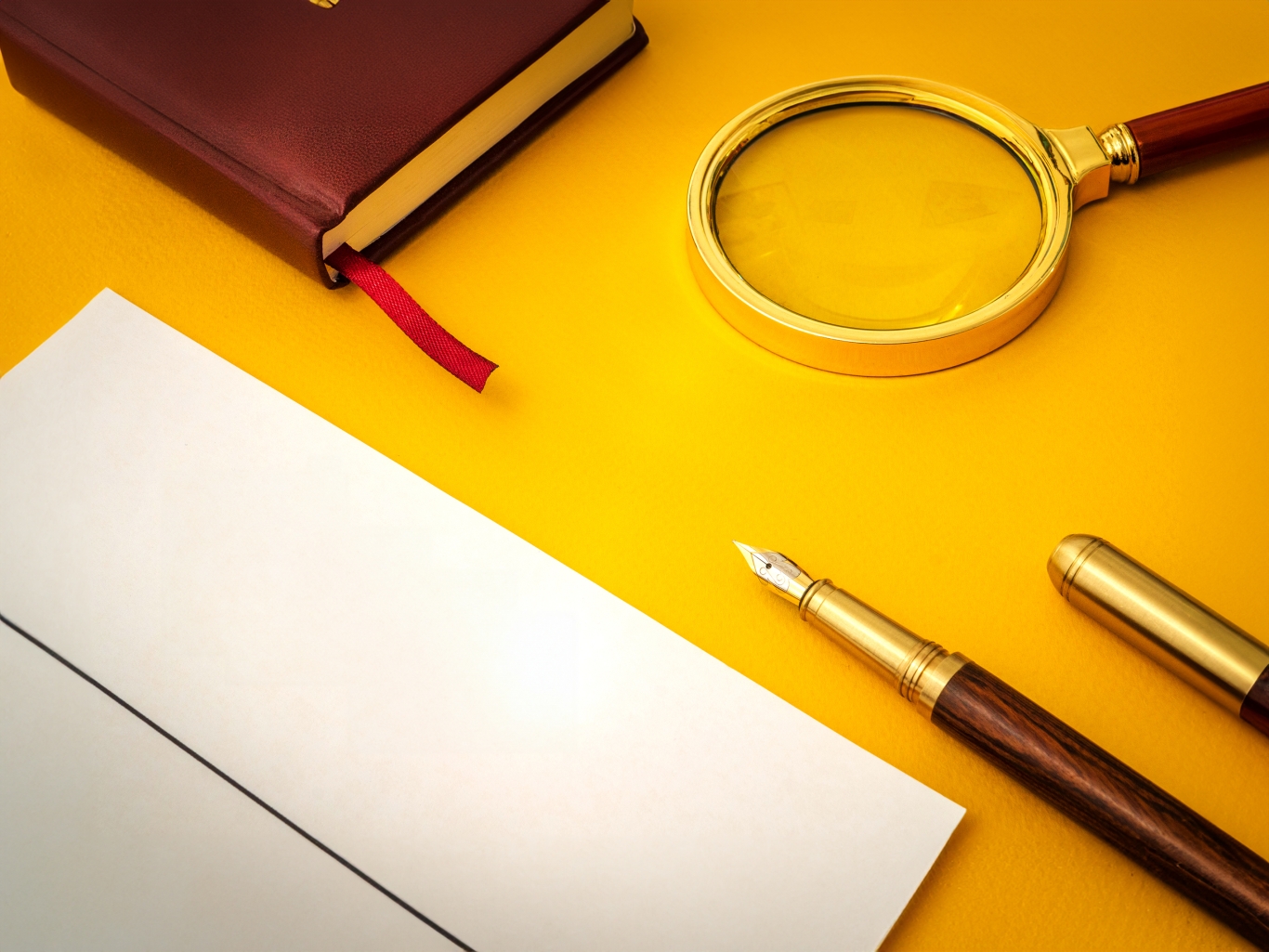 Document on table with pen and magnifying glass on yellow table.