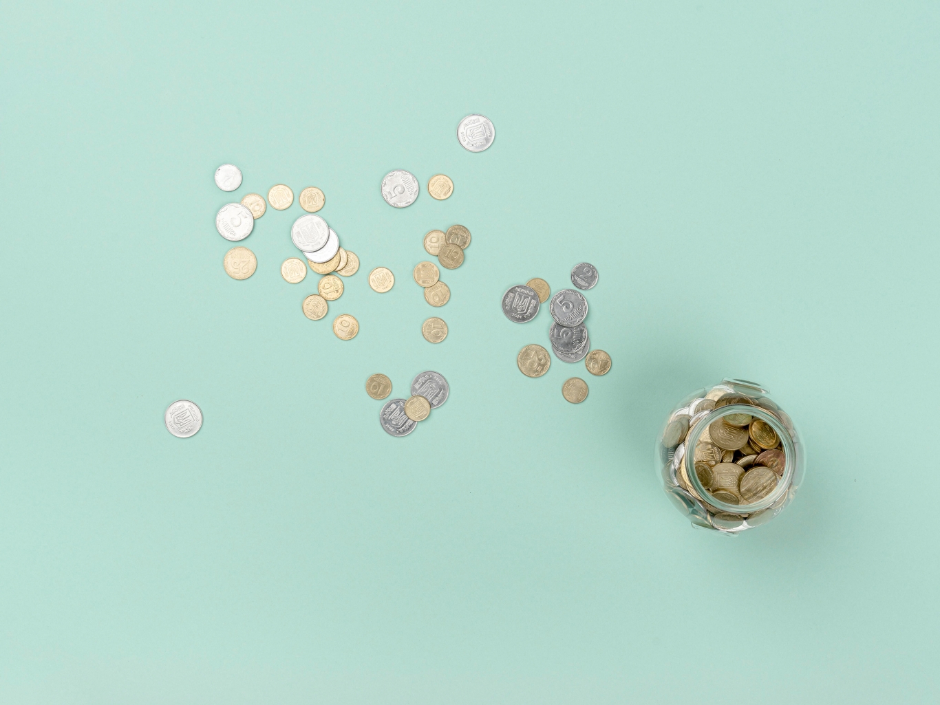 Top view jar with coins scattered around.